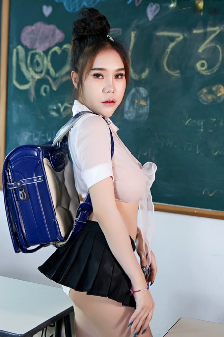 Shonking: Hot Japanese student Parissa strips on to her black boots as she poses in a classroom.