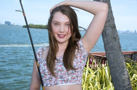 Sweet teen Elena Koshka uncovers her tiny breasts while fishing from shore