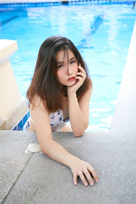 After emerging from a pool, Chia Ling, an attractive Asian girl, removes her bikini and emerges, dressed in all her clothing.