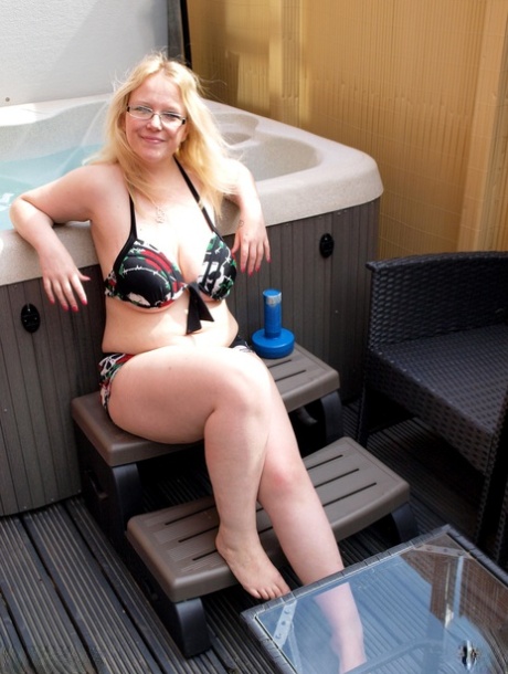 In an outdoor hot tub, Sindy Bust loses her massive breasts as a blonde who is overweight.