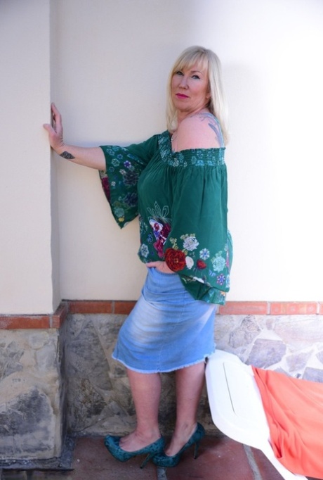 Old blonde Melody flaunts her massive breast tissue in a long denim skirt.