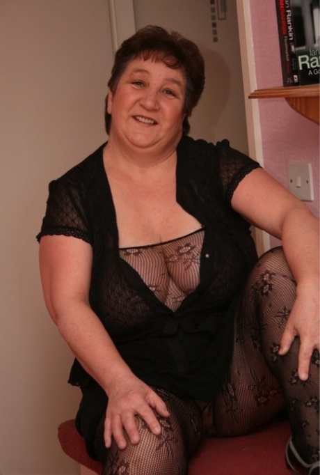 The older BBW Kinky Carol wears a sheer bodystocking while performing solo action.