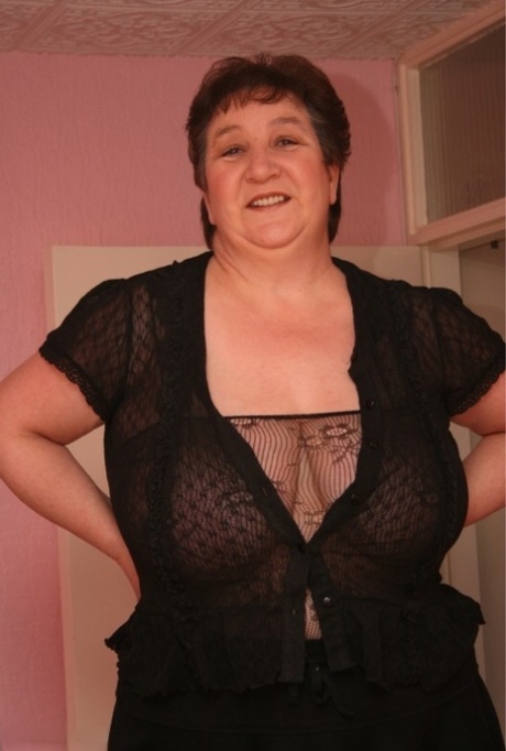 In solo action, the older BBW Kinky Carol wears a sheer bodystocking.