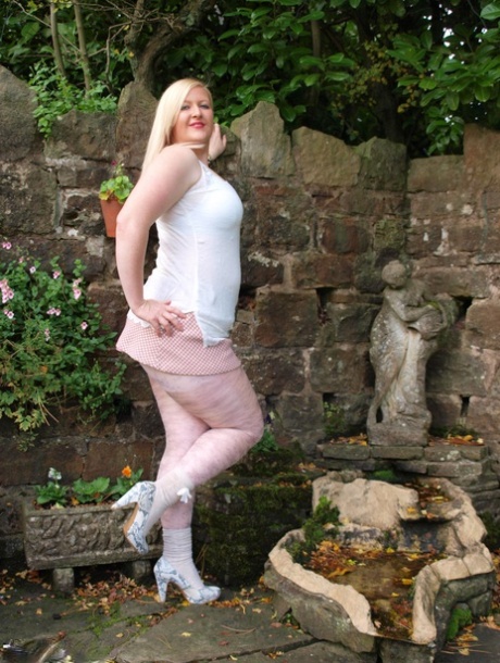 Blonde BBW Samantha shows off her tits and sniffs in the garden with pride.