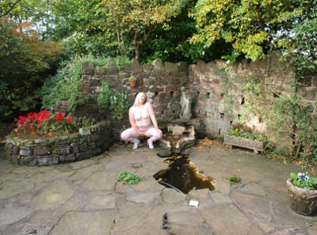 The naked blonde BBW Samantha exposes her bellies and sewn while in the garden.