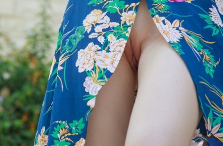 Sweet teen Alice May takes off her robe to go nude upon a garden wall