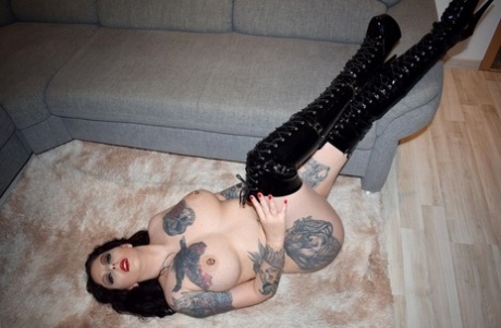 Lucy Ravenblood, a tattooed brunette, is seen wearing over the knee boots while naked.