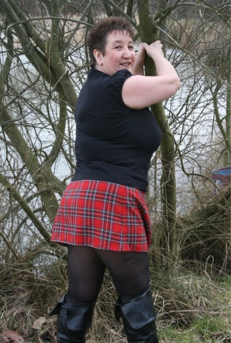 A plaid skirt enables Kinky Carol, a plump woman from the UK, to take off her shirt while near the water.