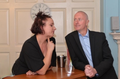 At the bar, a female waitress of middle age engages in sexual activities with a male client.