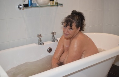 When bathing, the mature and fatty Busty Kim exposes her large breast area.