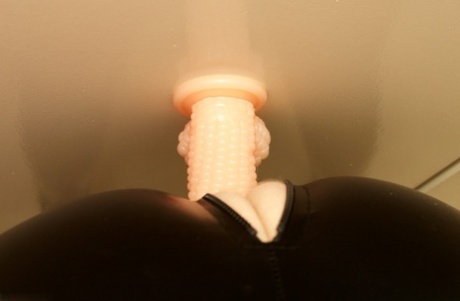 By using a suction dildo in the latex wear, Speedy Bee, an adult British woman, pleasures herself during masturbation.