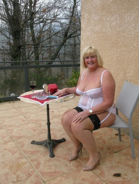 Chrissy Uk, the older and fatty woman with blonde hair, puts on her makeup before venturing out to reveal her breasts.