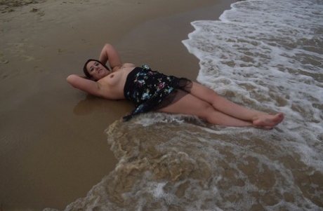 A picture shows Sara Banks, a young woman with no experience at the beach, showing off her pussy and tits.