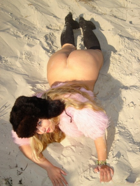 On a sandy bank, Curvy Meile, the slender blonde, displays her pussy and tits.