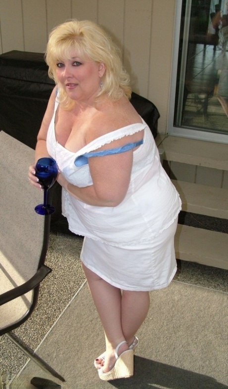 Prior to masturbating, Taffy Spanx (a heavy-set blonde) is nude and covers herself on a patio.