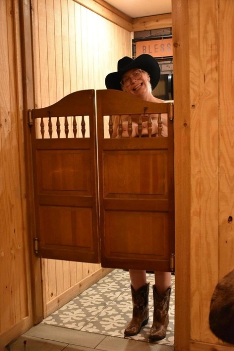 An older woman from Britain, Barby Slut (left) exposes herself in a cowboy hat and boots.