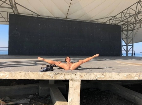 First timer Malika gets completely naked on a concrete stage near the water