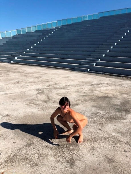 At the water's edge, Malika lays out her body completely naked on a concrete stage for first time swimming.