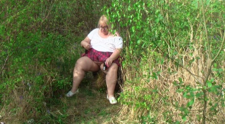 On a bench in a field, Lexie Cummings expose herself as an overweight British woman.