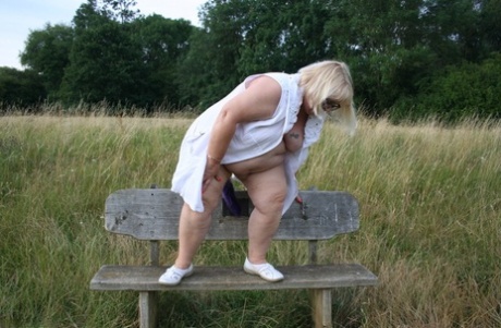 Fat British blond Lexie Cummings takes on a field bench in front of the plunging spectators.