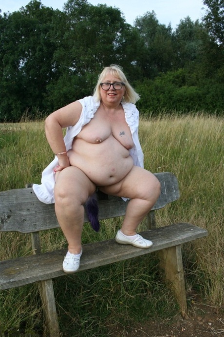 Lexie Cummings, who is overweight, bares her legs on a bench in a field.