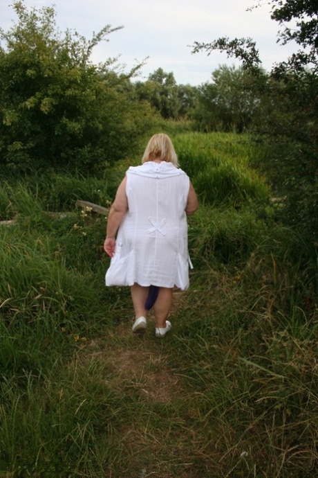 Led Zeppelin: Fat British woman Lexie Cummings takes off clothes on a bench in the field for a photo.