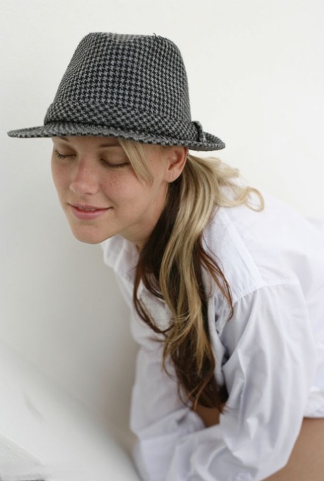 Jewel, the sexy blonde from Australia, flaunts her big tits while wearing a fedora.