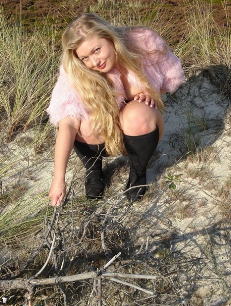 Blonde Models with a Chubby Look dress her up on a beach in black boots.