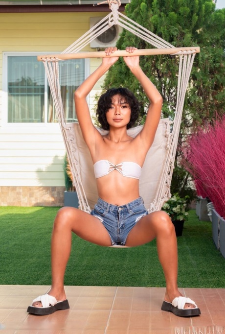 The gorgeous Asian woman takes it up a gear by stripping off in her skimpy white swimsuit.