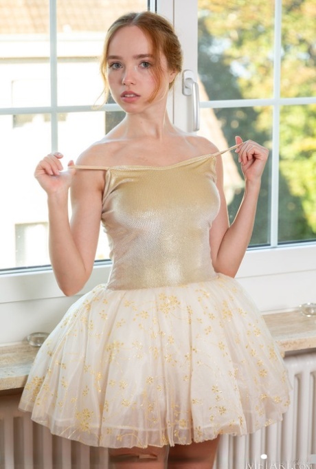 In revealing fashion, young redhead Rinna Ly removes her ballerina attire.