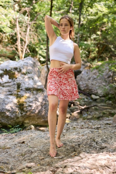Lovely teen girl playfully strips in the forest and teases you with her