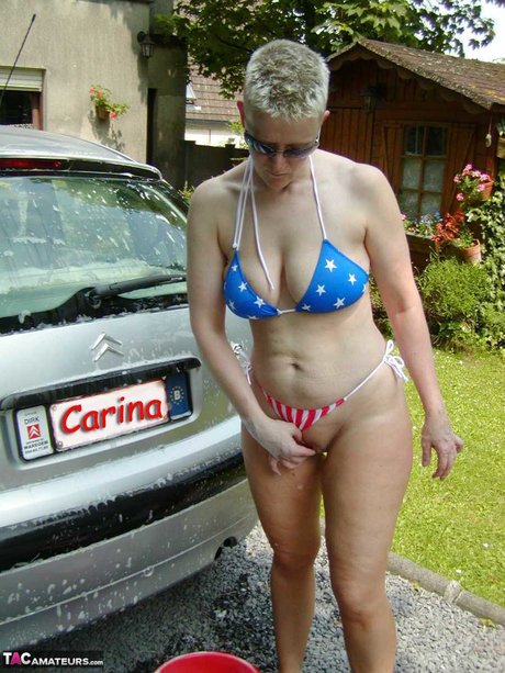 Older Blonde Tiffany Pearl Washes Her Car While Wearing A Bikini