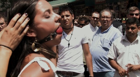 Prior to being publicly sexted, the brunette girl is guided through the city streets in the nude.