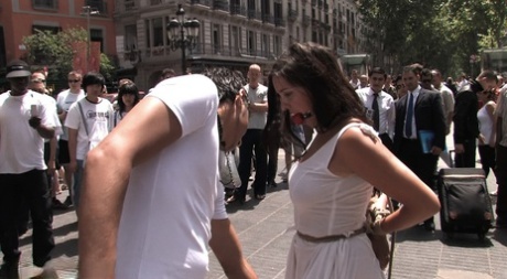 A naked brunette girl is escorted through the city streets before being publicly sexted.