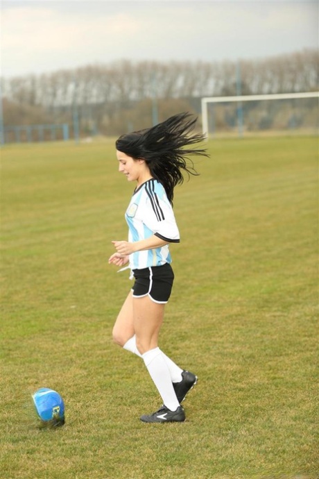 Barely legal soccer player removes her uniform before masturbating on a bench