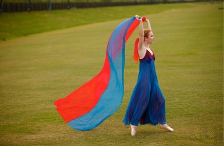 With an abundance of moves, Nicki Blue works on her ballerina skills with natural red hair and across a large field.