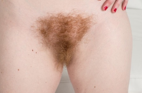 Ana Molly, who is naturally blonde, removes her denim shorts to care for her hairy beaver.