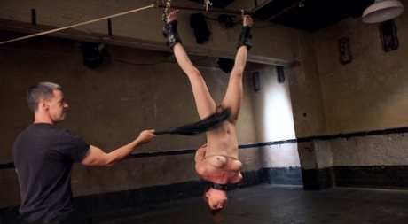 When a nude redhead is suspended upside down, they are subjected to hard slave training.