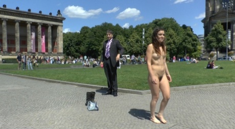 Before having sex in public, a white girl is seen walking naked through a square.