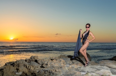 At the beach, Roni Ford, a seductive adult, flaunts her heels.