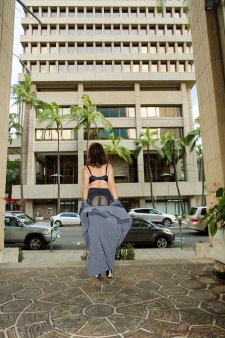 Roni Ford, a gorgeous adult woman in silk stockings, removes her coat and walks towards the street.