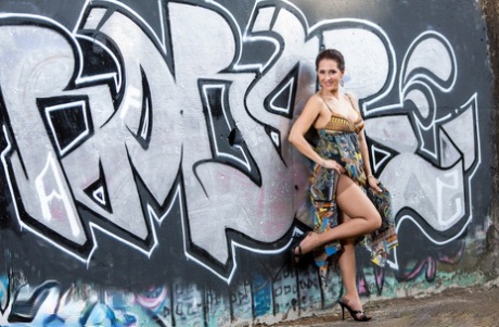 Vintage wife Roni Ford removes the dress and spray to pose with graffiti on a naked background.