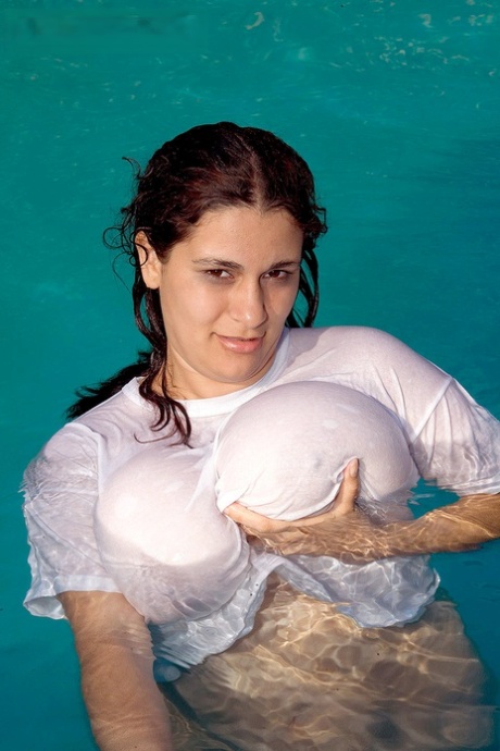 In a swimming pool, Romina Lopez exposes her massive breasts as she gets in shape.