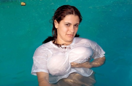 Romina Lopez, a heavyset woman who is swimming in a pool, displays her massive breasts.
