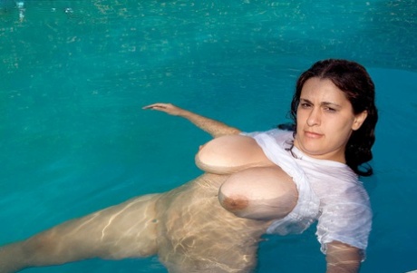 As she swims in a pool, Romina Lopez, an obese woman who is very thin, displays her massive breasts.