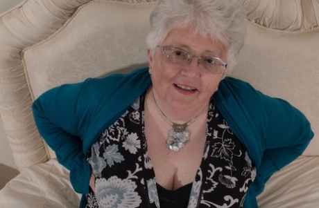 In the UK, an obese grandmother covers her naked breasts with both hands.