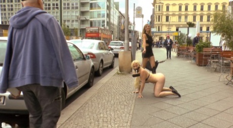 A nude blonde slave pees in a public street before having sex.