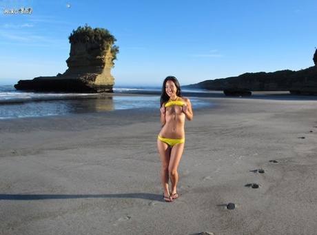 Japanese model Miko Sinz poses with her prominent buttocks while taking off in a bikini by the sea.