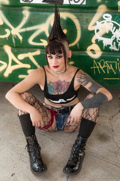 A Mohawk-like hairstyle and tattooed punk rocker, Amelia Dire is seen stripping naked.