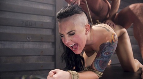 In a BDSM sex scene, Rachael Madori, a tattooed girl, engages in anal intercourse.